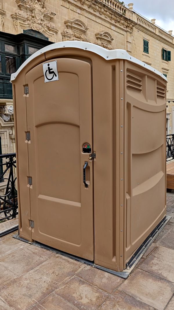Construction site porta potty placed beside site fencing in Georgia and the Southeast
